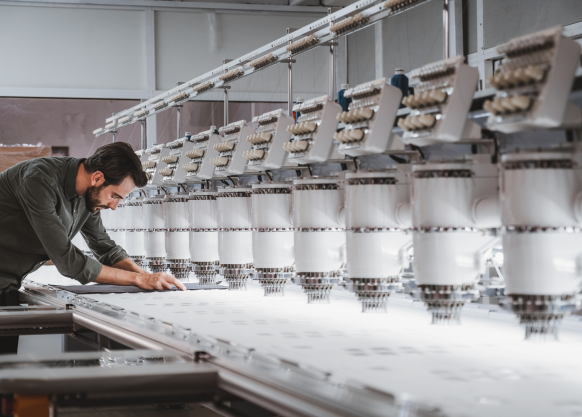 Expert in a textile manufacturing plant taking measurements of a technical fabric created by SUBRENAT on the basis of a specification