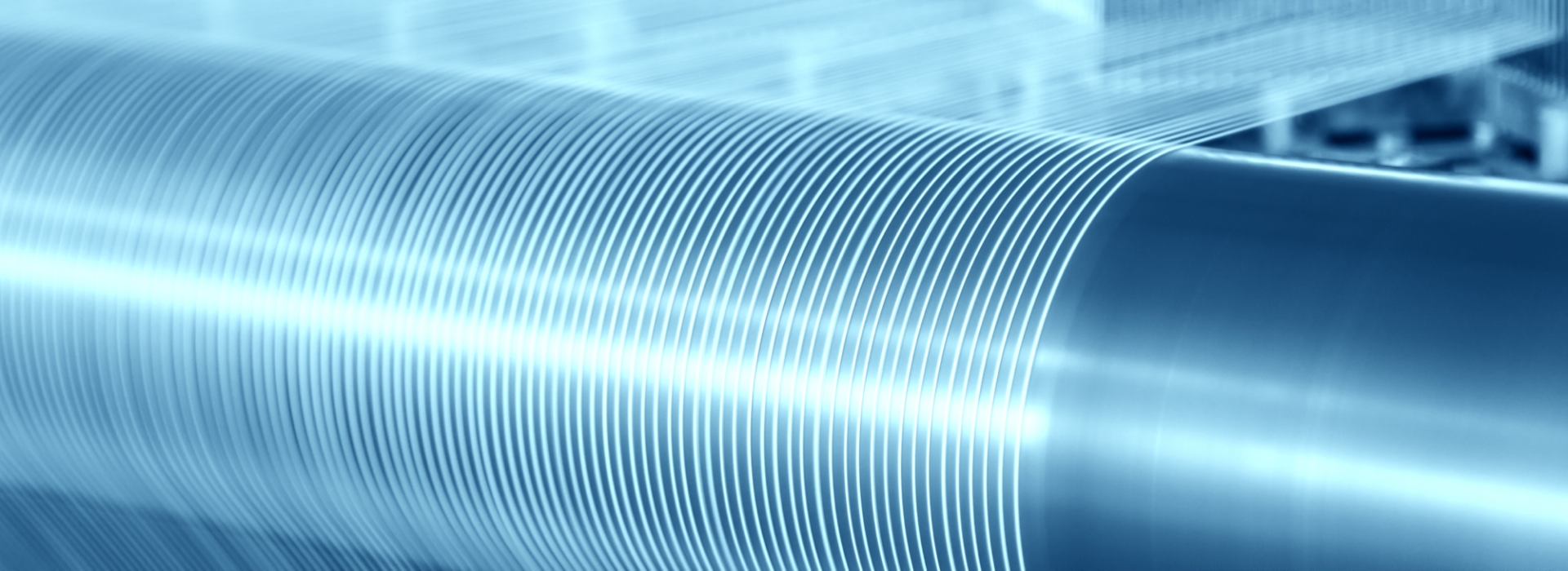 Rouleau de fibres textiles blanches sur un rouleau bleu, représentant l'expertise de SUBRENAT dans l'industrie textile internationale